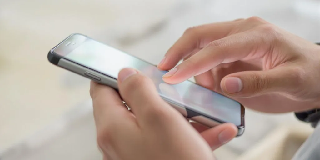 Manos usando un teléfono para crear cuenta PayPal.