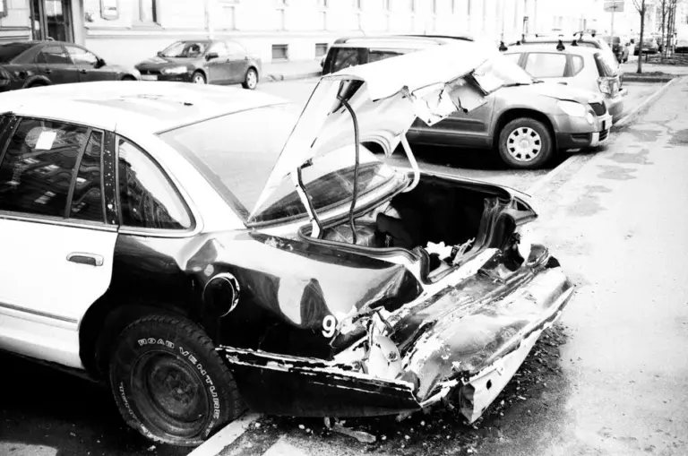 Para-choque amassado de carro após colisão leve na rua