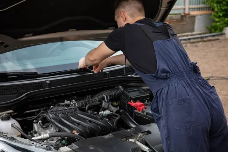 Mecânico examinando o motor com o capô aberto