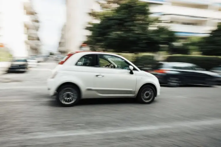 Carro pequeno branco em movimento pela cidade