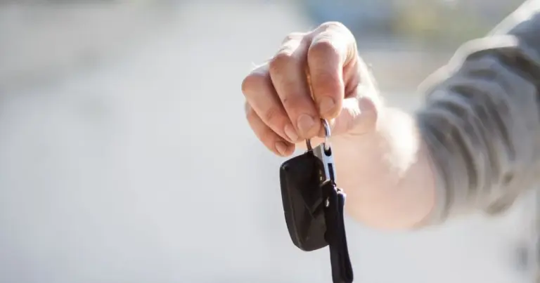 Close-up de uma mão segurando uma chave de carro suspensa no ar