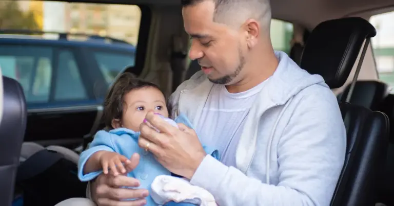 Pai alimentando o bebê dentro do carro