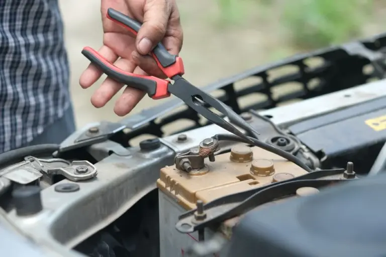 Mecânico usando alicate para reparar bateria do carro