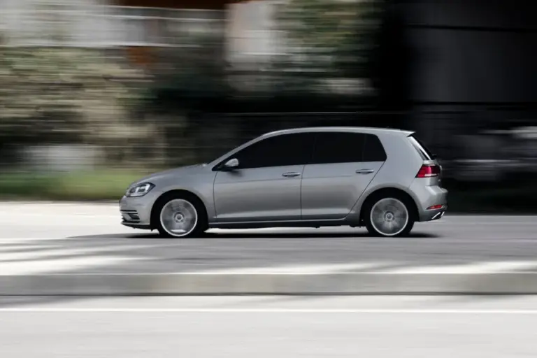 Carro hatch prateado em movimento na rua