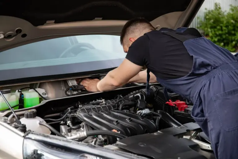 Mecânico inspecionando motor de carro hatchback usado