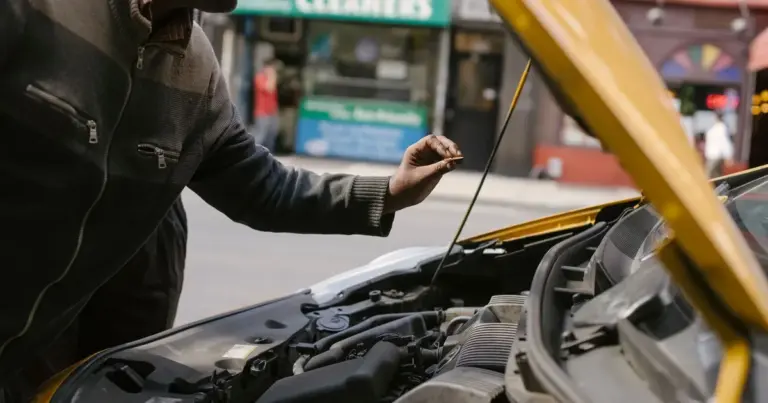 Mecânico verificando o óleo do motor na rua