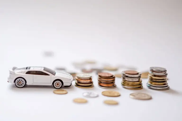 Cofrinho porco ao lado de miniatura de carro representando economia no seguro