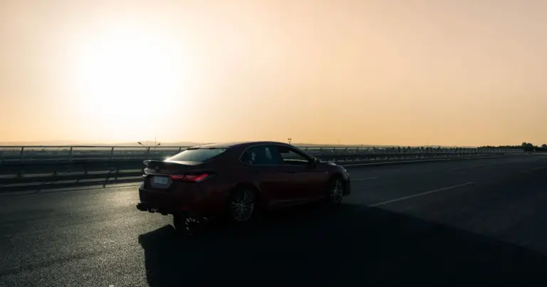 Carro sedã em estrada ao pôr do sol