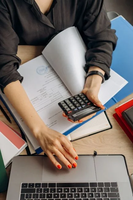 Calculadora e papelada de apólice de seguro sobre a mesa