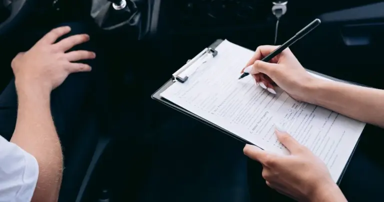 Mãos preenchendo um formulário em uma prancheta dentro do carro