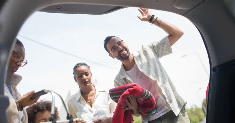 Família carregando o porta-malas do carro para um passeio
