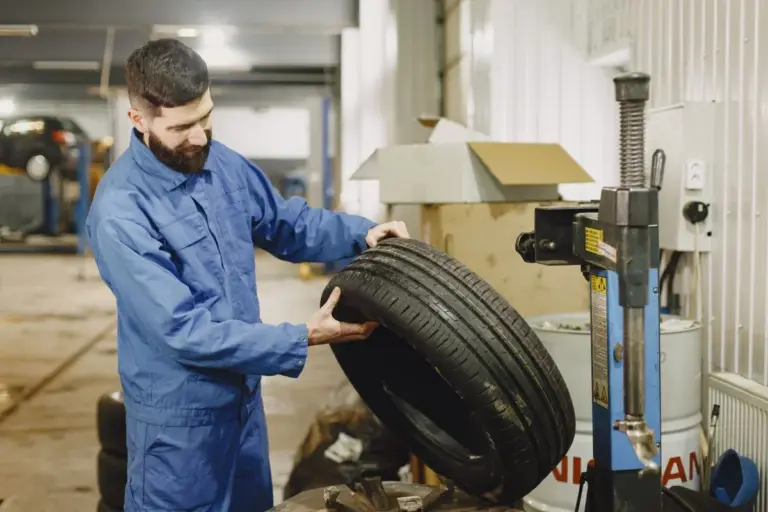 Mecânico inspecionando pneu de carro usado