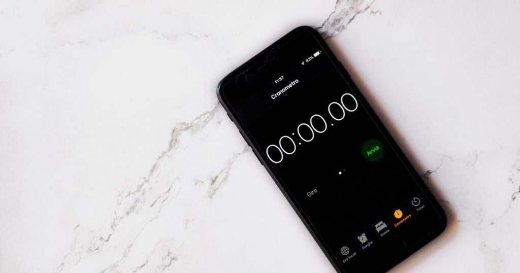 Celular exibindo um cronômetro digital sobre uma superfície de mármore.