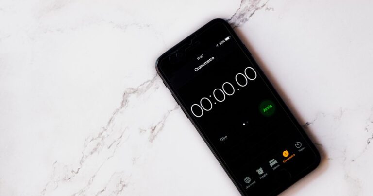 Celular exibindo um cronômetro digital sobre uma superfície de mármore.